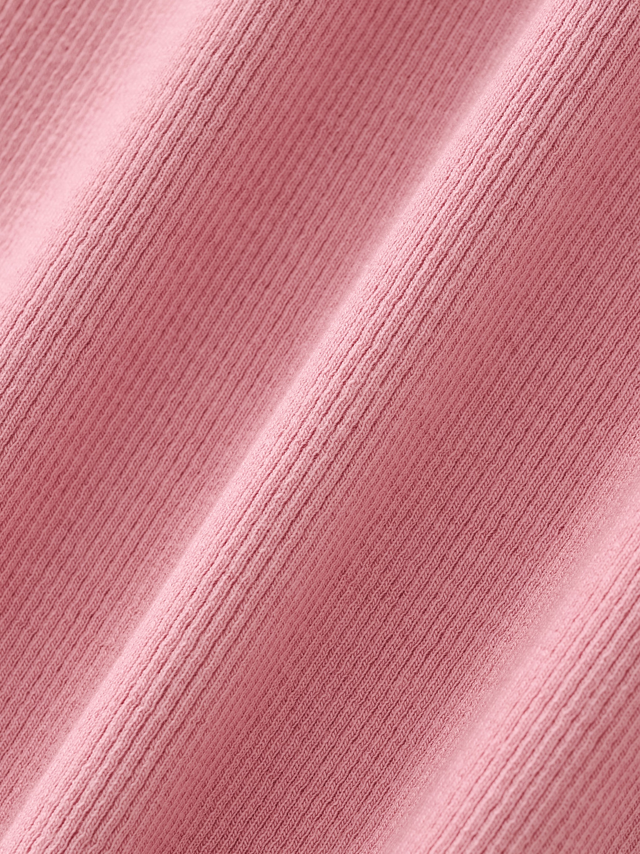 Close-up of pink ribbed athletic fabric texture, soft and breathable performance material