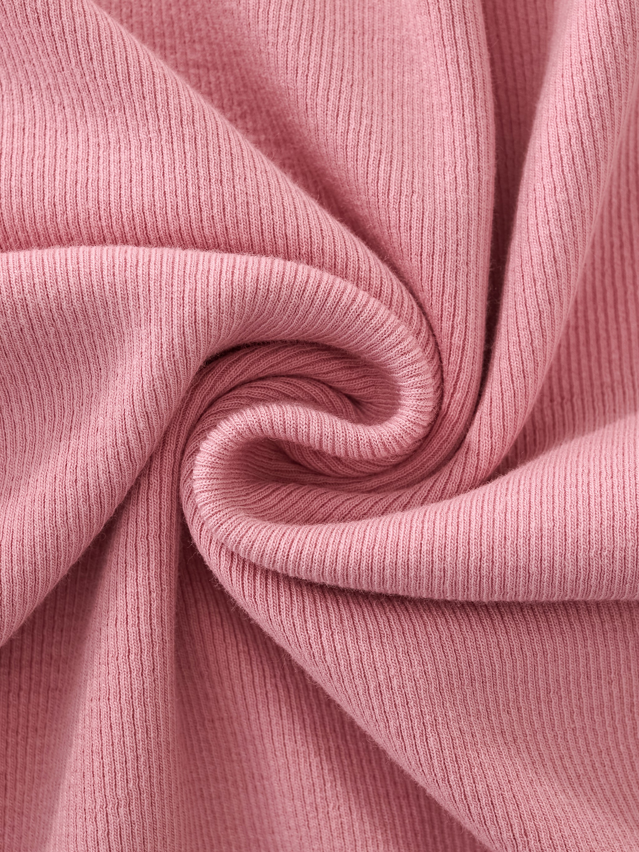 Close-up of soft pink ribbed knit athletic fabric with a spiral fold texture