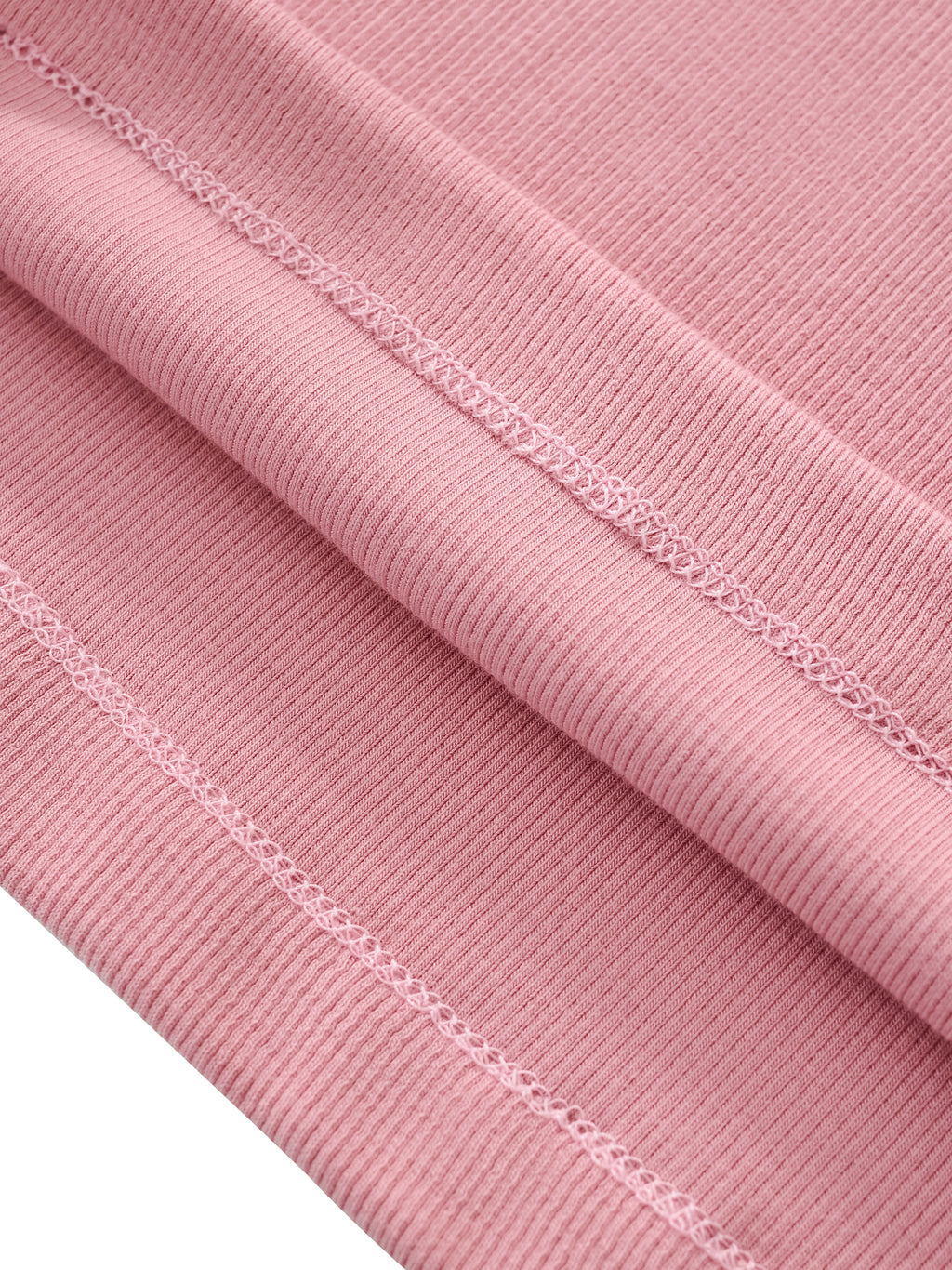 Close-up of pink ribbed athletic fabric with detailed double stitching, performance apparel textile
